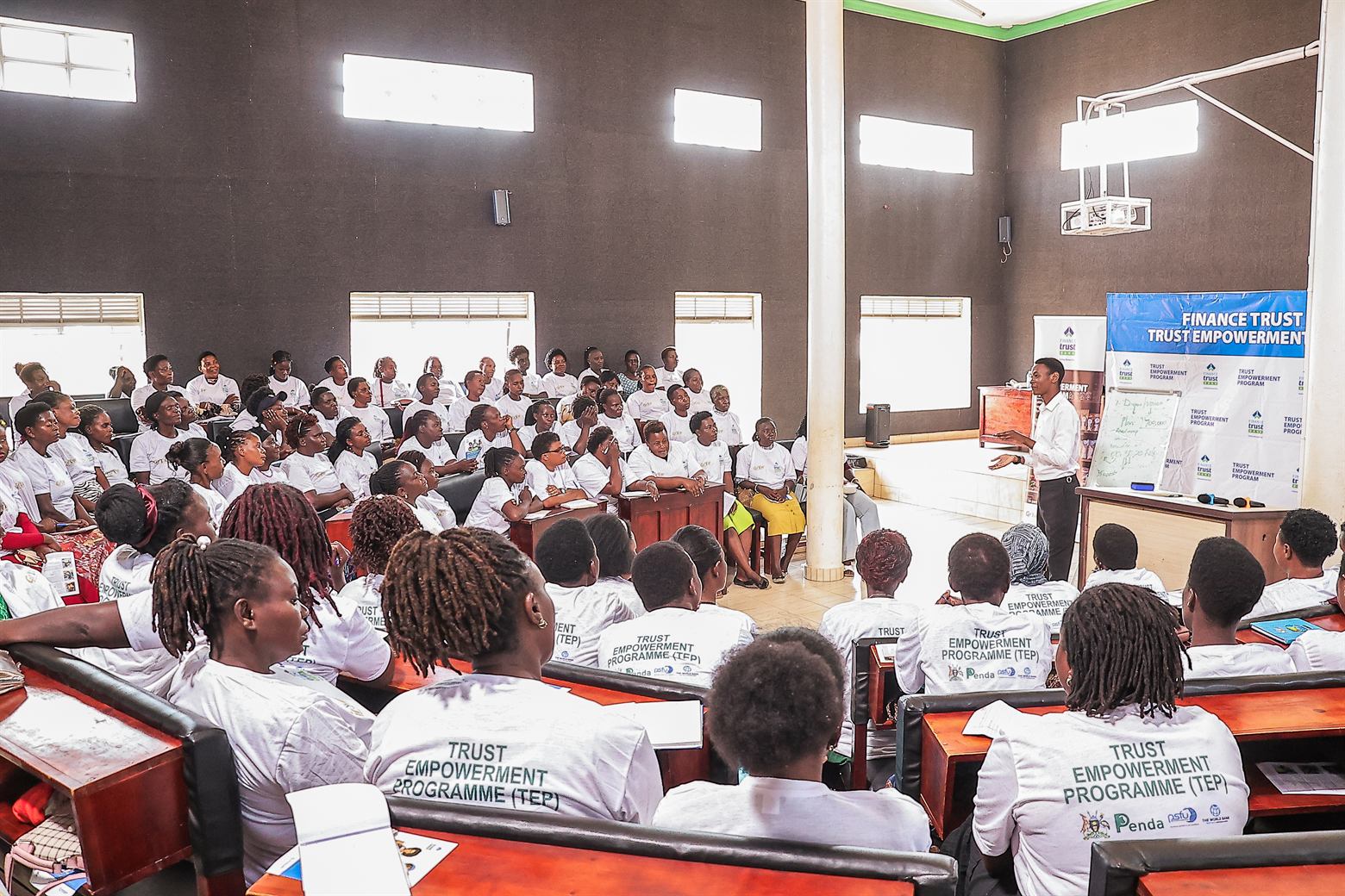 Packed training hall highlighting the partnership uniting Penda, Finance Trust Bank, GROW Project, PSFU, Government of Uganda, and The World Bank.